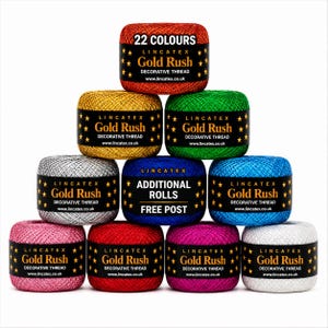 May include: A pyramid stack of ten Lincatex Gold Rush decorative thread spools in various colours including red, gold, green, silver, blue, pink, and white. Each spool features a black label with gold stars and the text 22 COLOURS or ADDITIONAL ROLLS FREE POST.