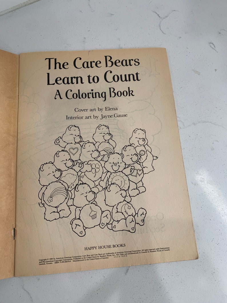 May include: A black and white colouring book featuring the Care Bears. The cover shows a group of Care Bears with their signature symbols. The title of the book is "The Care Bears Learn to Count: A Colouring Book".