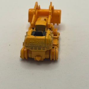 Pu&ograve; includere: Un bulldozer giocattolo giallo con un sedile nero e il testo "D655" sul lato.