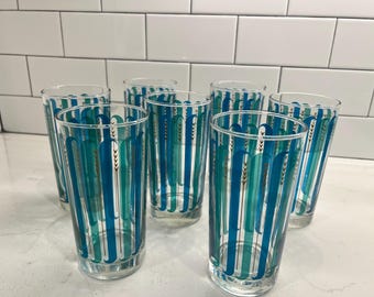 May include: Set of six blue and green glass tumblers with a geometric pattern. The glasses are clear and have a gold accent.