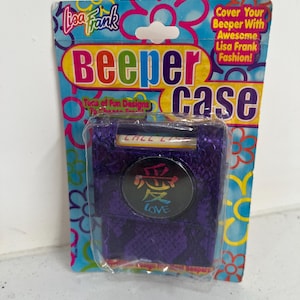 May include: A Lisa Frank "Beeper Case" package. The package is blue with a floral design and the words "Beeper Case" in large, colorful letters. The case is purple with a snake-skin pattern and a circular emblem with the word "LOVE" in Japanese.