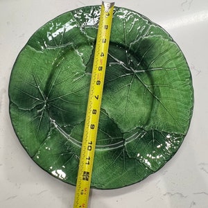 Pu&ograve; includere: Un grande piatto in ceramica verde con un design a foglie. Il piatto ha un diametro di 38 cm.