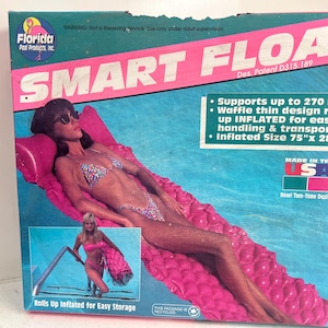 Pode incluir: Uma caixa de papelão retangular para um Smart Float da Florida Pool Products. A caixa apresenta um colchão inflável rosa com design de waffle, que suporta até 122 kg, com um tamanho inflado de 190,5 cm por 71,1 cm, fabricado nos EUA.