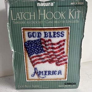 May include: A "Natura" brand latch hook kit featuring a patriotic design. The kit includes a pattern of the American flag with the words "God Bless America." The finished size is approximately 20" x 27".