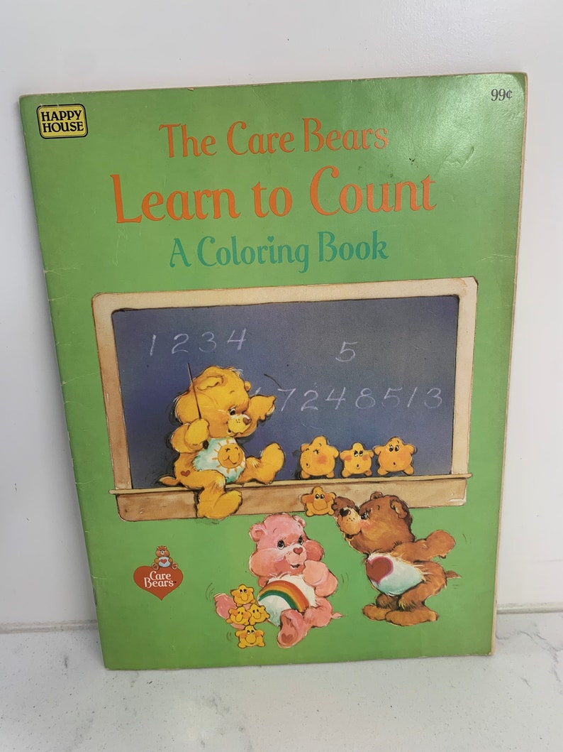 May include: A green colouring book featuring the Care Bears. The cover shows the Care Bears learning to count with a chalkboard and numbers. The title is "The Care Bears Learn to Count: A Colouring Book".