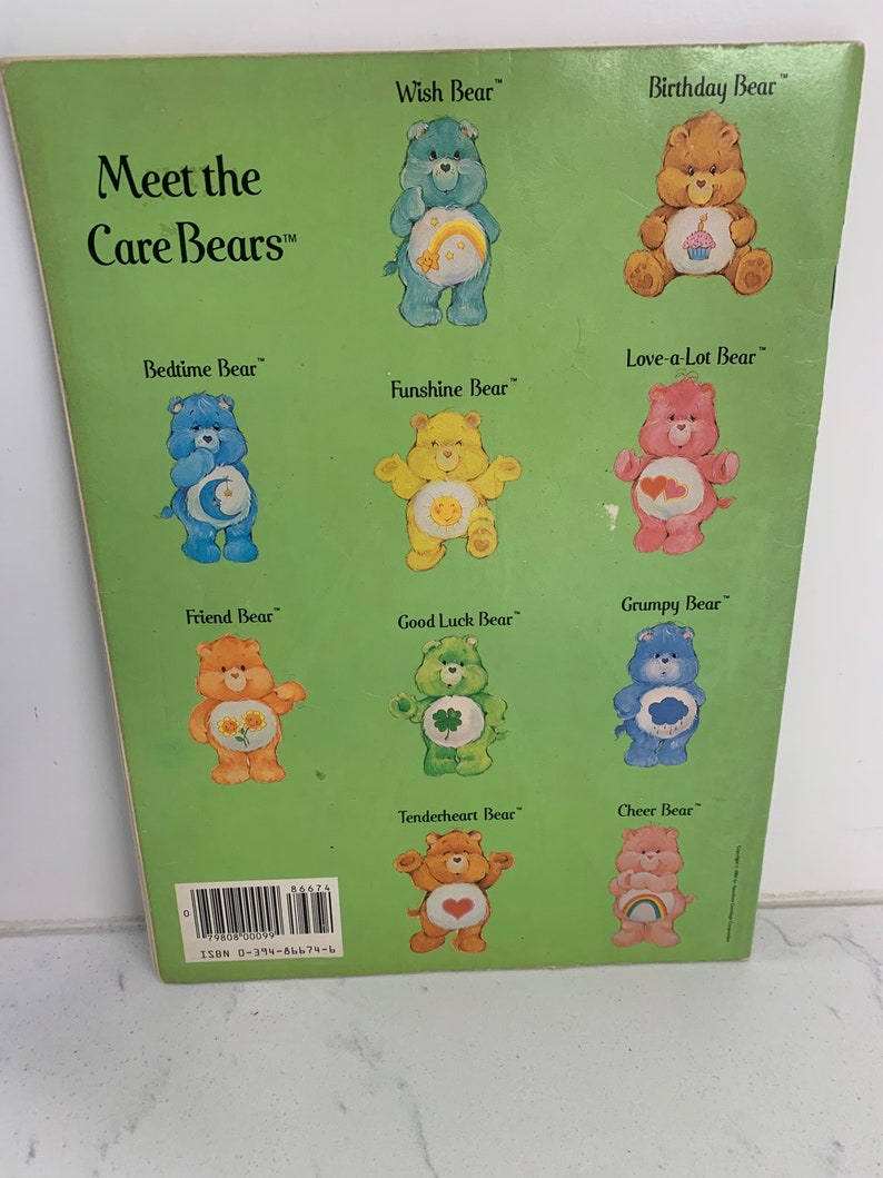May include: A green book cover featuring the title "Meet the Care Bears" and illustrations of various Care Bears. Each bear has a distinctive colour, symbol, and name. The book cover includes the ISBN number 0-394-86674-6.