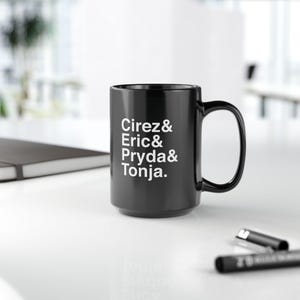 May include: Black ceramic coffee mug with white text that reads "Cirez & Eric & Pryda & Tonja."