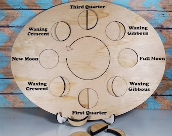 May include: An oval wooden moon phase board featuring laser-engraved labels for New Moon, Waxing Crescent, First Quarter, Waxing Gibbous, Full Moon, Waning Gibbous, Third Quarter, and Waning Crescent, with a central circular arrow and loose moon pieces.