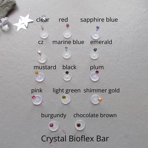 May include: A collection of Crystal Bioflex bars featuring small circular gems in various colours including clear, red, sapphire blue, cz, marine blue, emerald, mustard, black, plum, pink, light green, shimmer gold, burgundy, and chocolate brown.