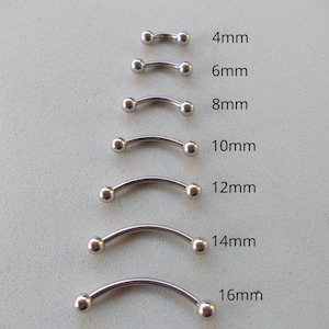 May include: A collection of curved barbell body jewelry in various sizes, ranging from 4mm to 16mm. Each piece is silver-colored with a curved bar and two small, round balls at the ends. The sizes are labeled in millimeters.