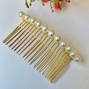 classic simple pearl hair comb that is a available on a gold or silver  comb. the glass pearls are white and are 8cm.