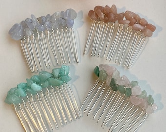 May include: Four silver hair combs with different colored stones. The combs have a silver wire wrapped around the base of the stones. The stones are light blue, light brown, light green, and pink.