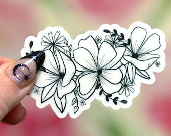 May include: A die-cut sticker featuring a black and white line art illustration of a cluster of various flowers and small leaves. The design showcases multiple blossoms with detailed petals and stems arranged in a horizontal, organic floral pattern.