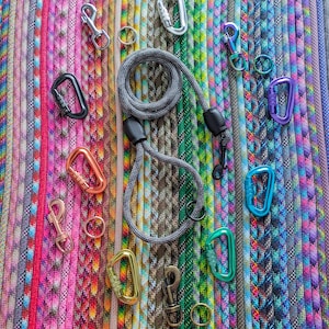 May include: A variety of colorful braided ropes with metal clasps and rings. The ropes are arranged in a rainbow pattern and are all different lengths.