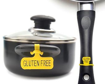 May include: Two black pots with lids and yellow labels that say "Gluten Free". The pot on the left has a glass lid. The pot on the right has a black handle.