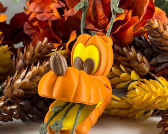 May include: Orange pumpkin-shaped Halloween decoration with a cartoon face and green stem. The pumpkin is open and has a yellow interior.