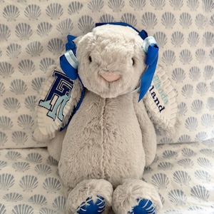 Op de afbeelding: Een witte keramische mok met een zwart handvat en de tekst "But First, Coffee" in een zwarte, handgeschreven lettertype. De mok staat op een wit oppervlak.