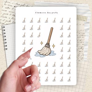 May include: A sheet of stickers featuring a repeating pattern of cartoon mops with a larger, central mop design. The text "L'armoire des profs" is at the top. The stickers are held by a hand.