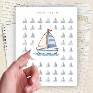 May include: A sheet of stickers featuring sailboat designs. The stickers have a white background with blue and white sailboats. The text "L'armoire des profs" is at the top. The image is held by a hand.
