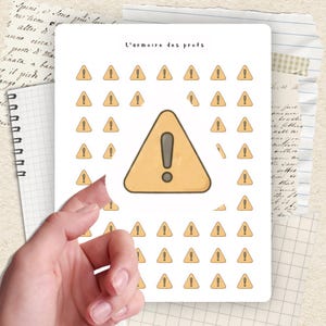 Peut inclure: Une planche d'autocollants avec un motif de symbole d'avertissement. Les autocollants sont en forme de triangle jaune avec un point d'exclamation à l'intérieur. Le texte "L'armoire des profs" est en haut.