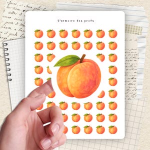 Pode incluir: Uma folha de autocolantes com ilustrações de pêssegos. Os autocolantes apresentam um pêssego grande com uma folha verde e desenhos de pêssegos menores. O texto "L'armoire des profs" está no topo.
