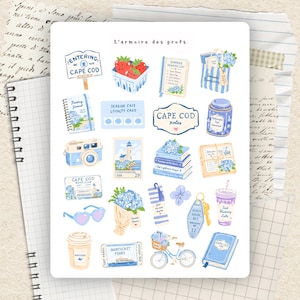 Peut inclure: Une planche d'autocollants intitulée L'armoire des profs présentant des illustrations sur le thème de Cape Cod, dont un panneau, des fraises, une liste de lecture, un sac, un journal, une carte de fidélité, un appareil photo, un timbre, des livres, une lettre, des lunettes, des fleurs, un marque-page, une clé, une boisson, un ticket de ferry, un vélo et un livre.