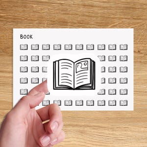 May include: A white sheet of paper with the word "BOOK" at the top. The sheet is covered with small black and white book icons. A larger black and white book icon is in the center of the sheet, with a hand peeling it off.