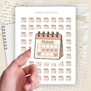 Peut inclure: Une planche d'autocollants avec un motif de calendrier avec le mot "PERIOD" et des symboles de cœur. Les autocollants sont dans une palette de couleurs rose clair et marron. Le texte "L'armoire des profs" est en haut.