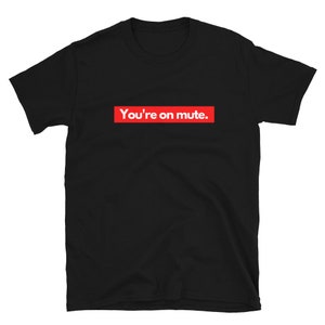 Puede incluir: Camiseta negra con un cuadro rojo y el texto "You're on mute."