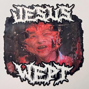 May include: A sticker featuring a gruesome image of a person with severe facial injuries. The words "JESUS WEPT" are written in a white, gothic font above and below the image, set against a black border.