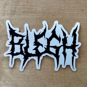 May include: Black and white sticker with the word "BLUESH" in a stylized, metal-like font.