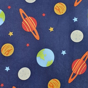 May include: A navy blue fabric with a repeating pattern of planets, stars, and moons. The planets are in various colors, including orange, red, and blue. The stars are yellow and white. The moons are gray.