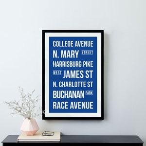 Puede incluir: Una impresión de arte de pared imprimible azul y blanca con los nombres de las calles de una ciudad. El texto dice: "College Avenue, N. Mary Street, Harrisburg Pike, West James St, N. Charlotte St, Buchanan Park, Race Avenue."