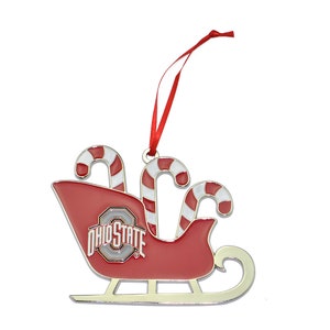 May include: A red and silver Christmas ornament shaped like a sleigh with candy canes and the Ohio State logo.