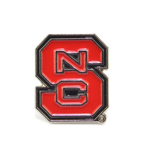 May include: A red and black enamel pin with the letters "NC" inside a stylized "S".