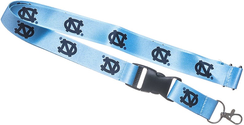 May include: A light blue lanyard with a black plastic clip and a silver key ring. The lanyard has a repeated pattern of the University of North Carolina Tar Heels logo in dark blue.