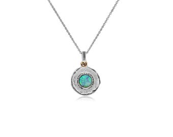 May include: A silver necklace with a round pendant featuring a green opal stone set in a textured silver frame. The pendant has a small gold accent.