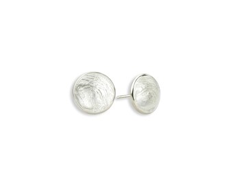 May include: A pair of silver stud earrings with a textured, round design.