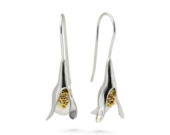 Puede incluir: Pendientes de plata con diseño de flor. La flor está hecha de plata y tiene un centro dorado.