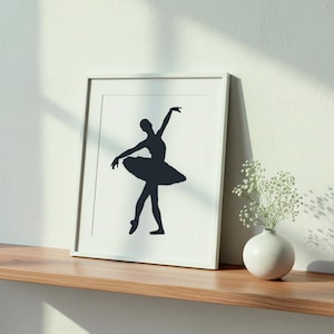 May include: A framed wall art print featuring a black silhouette of a ballet dancer in a tutu, posed with one arm raised and one leg extended. The artwork is presented in a simple white frame, showcasing a high-contrast design on a white background.