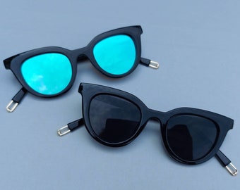 Lunettes de soleil Cat Eye (Mirror) | Nouvelles lunettes de soleil d’oeil de chat. Cadre noir avec des lunettes miroir grises ou bleues. style des années 60. papillon