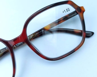 Könnte beinhalten: Eine Brille mit quadratischem Gestell in Schildpatt-Optik. Die Brille hat eine Stärke von +1,50 und der Text "OP L1611 +1,50" ist auf dem Bügel aufgedruckt.