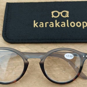 Op de afbeelding: Leesbril in schildpadpatroon met een sterkte van +2,50. De bril zit in een zwarte etui met de tekst "karakaloop." in goud gedrukt.