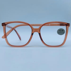 May include: A pair of brown plastic reading glasses with a square frame. The glasses have a +2.50 aspheric lens.