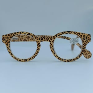 Op de afbeelding: Leesbril met ronde frames in luipaardprint en heldere glazen. De bril heeft een sterkte van +3,00 dioptrie en een glazenmaat van 62 mm.