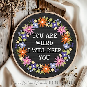 Może przedstawiać: Wzór na haft krzyżykowy z wieńcem kwiatowym wokół tekstu "You are weird I will keep you".