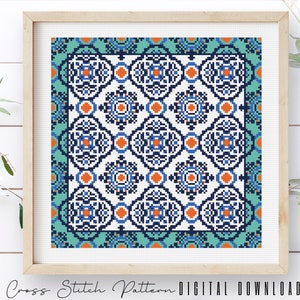 May include: A cross stitch pattern featuring a geometric design with blue, orange, and green colors. The pattern is framed in a wooden frame.