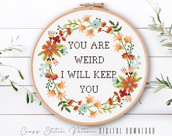 May include: Cross stitch pattern with a floral wreath and the text "You are weird I will keep you".