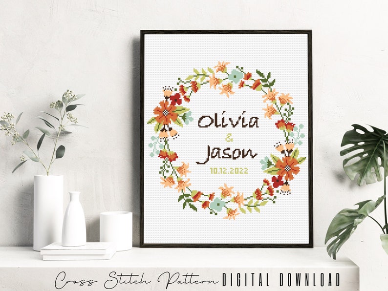 Puede incluir: Patr&oacute;n de punto de cruz con una corona de flores con los nombres Olivia & Jason y la fecha 10.12.2022.