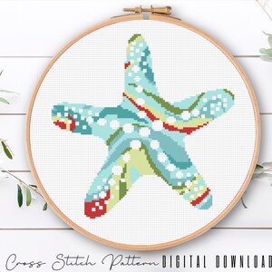May include: A cross stitch pattern of a blue and green starfish with red and white accents. The pattern is in a hoop and ready to be stitched.